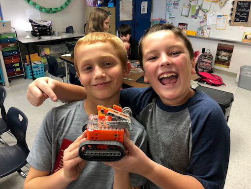 Two students showing their Edison robotics engineering project