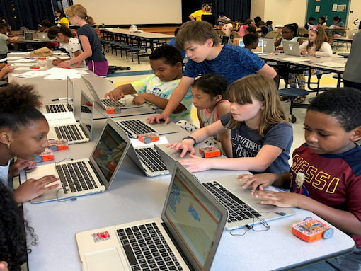 Students programming Edison robots together in a classroom